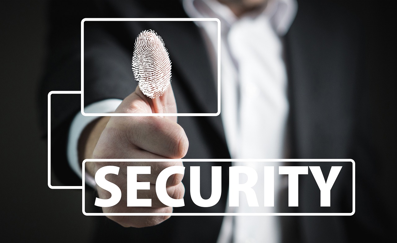 man holding up his thumb that has his fingerprint highlighted in white, with a white square frame linking to the word security in in all caps